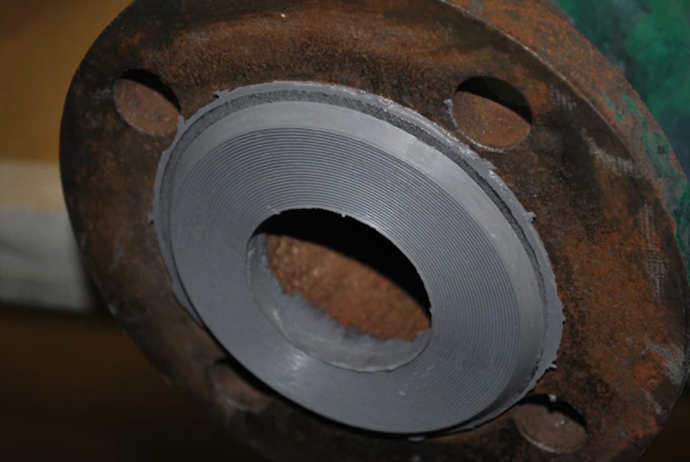 Corroded wellhead flange face prepared and reformed to a flat sealing profile