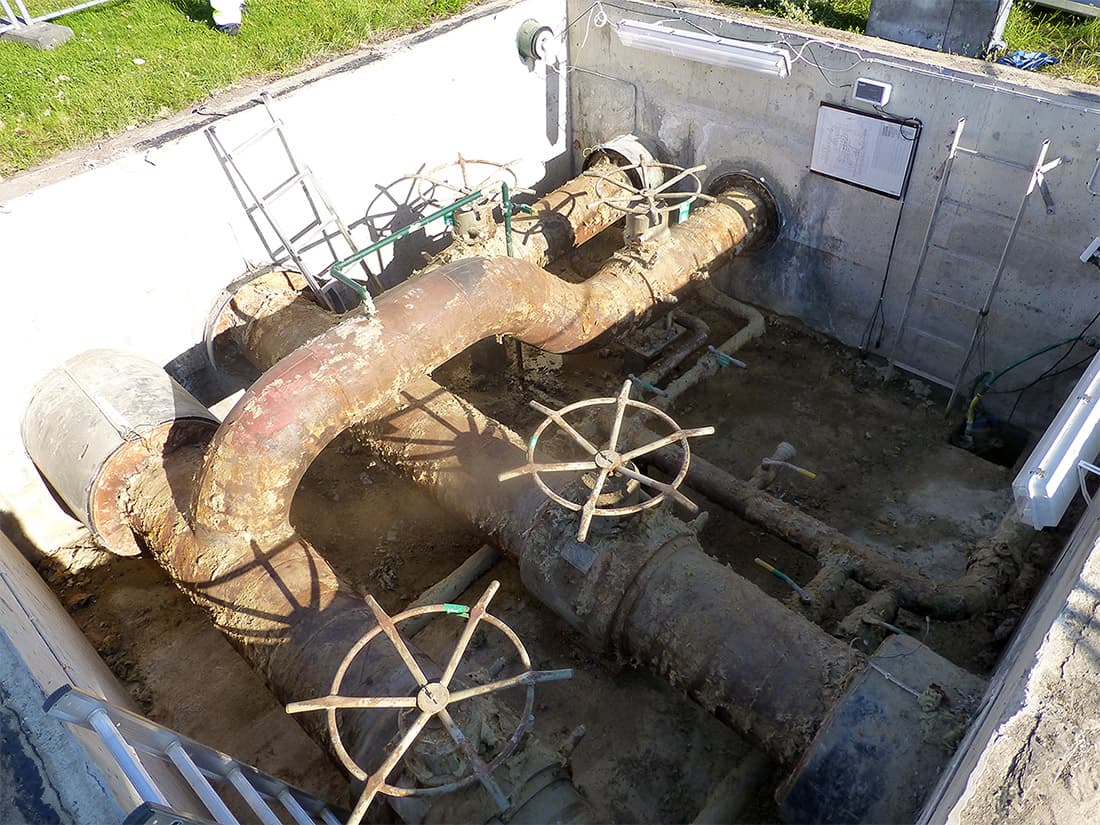 Corroded pipework in the access chamber of a district heating facility