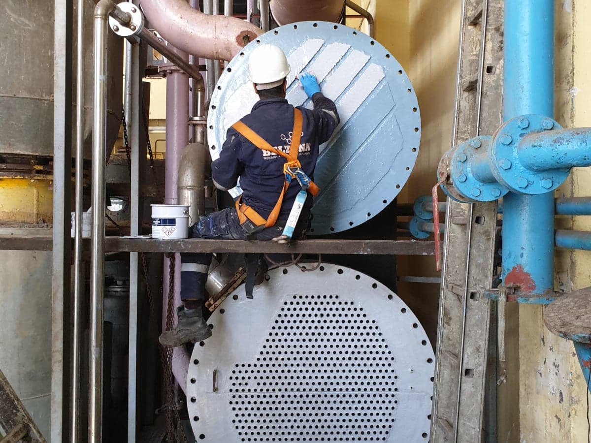 Technicians repairing and protecting a heat exchanger with Belzona 1391T in a process plant